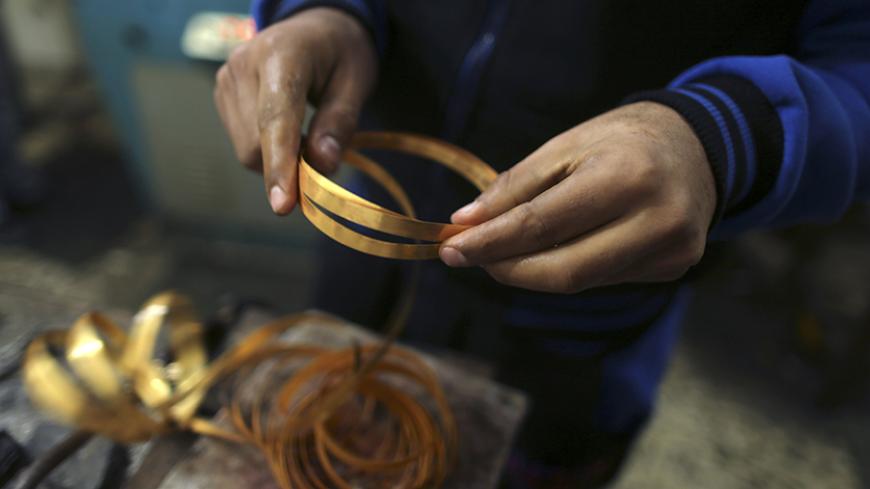 A Palestinian worker holds gold bracelets at a jewellery workshop in Gaza City March 3, 2015. REUTERS/Mohammed Salem (GAZA - Tags: BUSINESS EMPLOYMENT SOCIETY) - RTR4RUQM