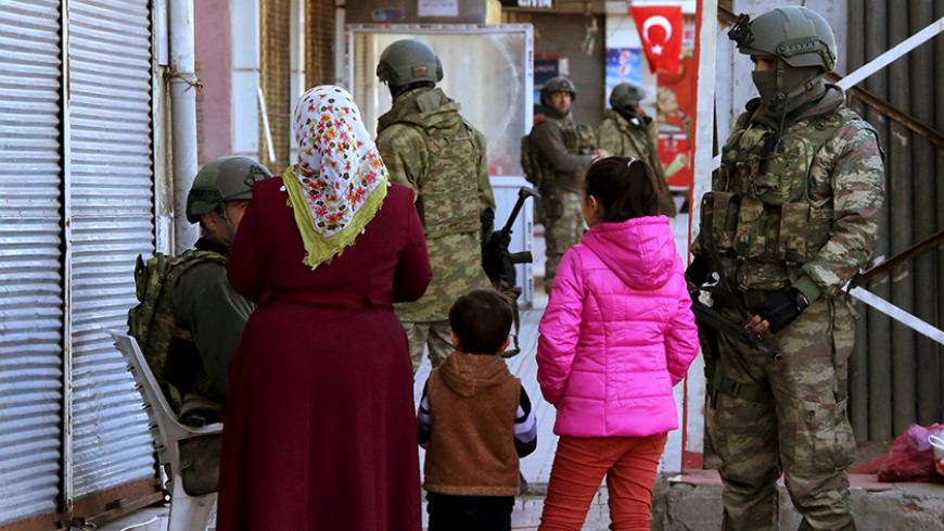 A woman with children talks to soldiers in Baglar district, which is partially under curfew, in the Kurdish-dominated southeastern city of Diyarbakir, Turkey March 17, 2016. REUTERS/Sertac Kayar - RTSAV4F