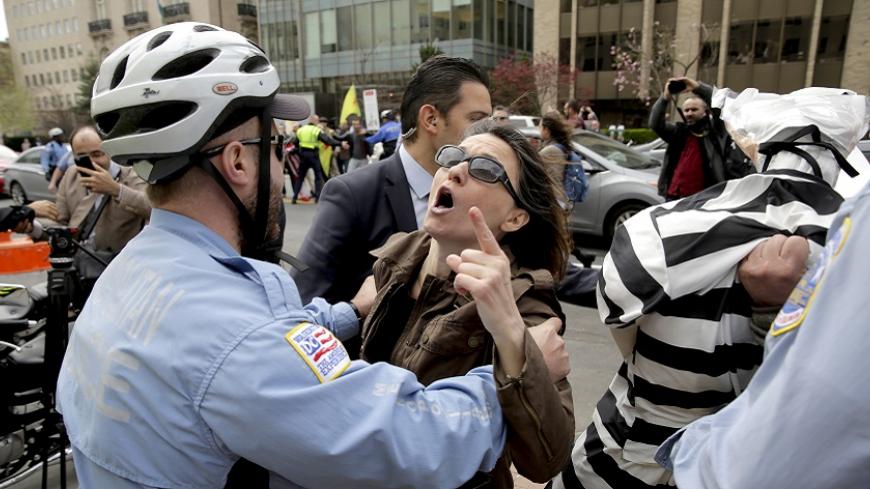 A Metropolitan police officer separates a protester from a member of the Turkish security detail in front of the Brookings Institute before the arrival of Turkish President Tayyip Erdogan in Washington, March 31, 2016. REUTERS/Joshua Roberts - RTSD14M