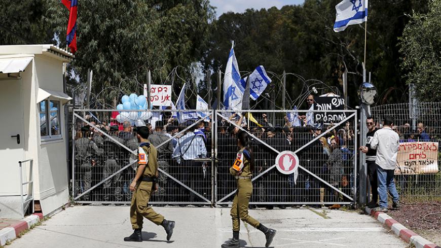 Israeli right-wing protesters demonstrate outside a military court during a hearing of an Israeli soldier whom the military said has been arrested after he shot a wounded and motionless Palestinian assailant in Hebron on March 24, near the southern Israeli city of Kiryat Malachi, in this March 29, 2016 file picture. REUTERS/Amir Cohen/Files  - RTSDU2B