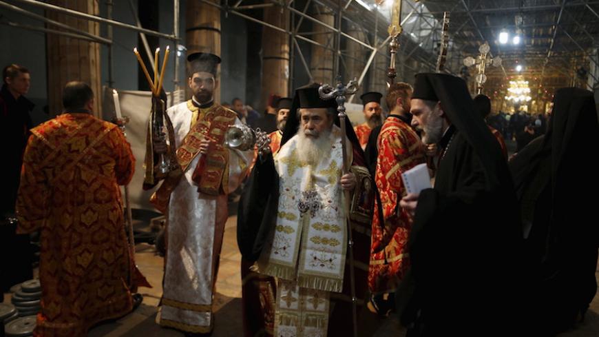 The Greek Orthodox Patriarch of Jerusalem Theophilos III (C) attends a Christmas service according to the Eastern Orthodox calendar, in the church of Nativity in the West Bank city of Bethlehem January 6, 2016. REUTERS/Ammar Awad  - RTX219EO