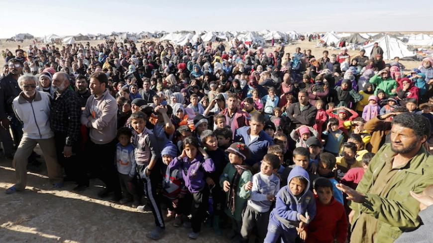 Syrian refugees stuck between the Jordanian and Syrian borders, wait to cross into Jordan after a group of them crossed into Jordanian territory, near the town of Ruwaished, at the Hadalat area, east of the capital Amman, January 14, 2016. After months of being stranded at the border, a group of Syrian refugees has finally been allowed to enter Jordan. Jordanian authorities say they have to address  security concerns before allowing more refugees into the country burdened with over 1.4 million refugees, sai