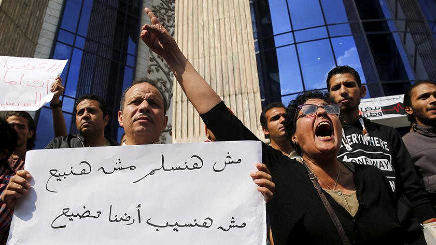 Egyptian activists shout slogans against President Abdel Fattah al-Sisi and his government, during a demonstration protesting the government's decision to transfer two Red Sea islands to Saudi Arabia, in front of the Press Syndicate in Cairo, Egypt, April 13, 2016. The sign reads, "We will not surrender and will not sell, we will not let our rights be lost". REUTERS/Amr Abdallah Dalsh      TPX IMAGES OF THE DAY      - RTX29S7P