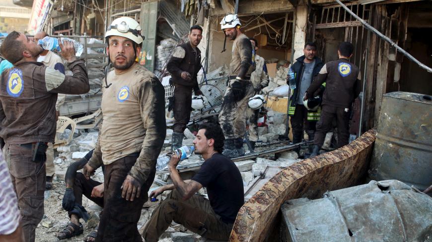 Civil defence members rest amid rubble of damaged buildings after an airstrike on the rebel-held Tariq al-Bab neighbourhood of Aleppo, Syria April 23, 2016. REUTERS/Abdalrhman Ismail      TPX IMAGES OF THE DAY      - RTX2BBAO