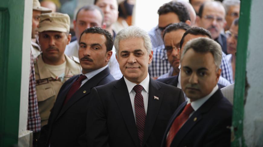 Presidential candidate Hamdeen Sabahi (C) waits to cast his vote during the presidential election in Cairo, May 26, 2014. Egyptians began voting on Monday in a presidential election expected to sweep former army chief Abdel Fatah al-Sisi into office, reviving rule by strongman three years after Hosni Mubarak's downfall. Voters cast ballots at heavily guarded polling stations from 9.00 a.m. (0600 GMT). Sisi, who deposed the Muslim Brotherhood's Mohamed Mursi last July, faces only one challenger in the two-da