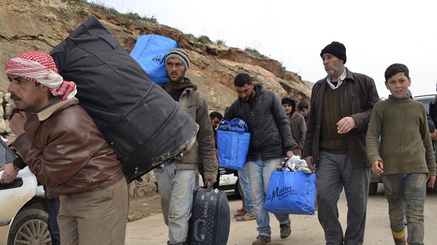 Syrians carry their belongings at the Syrian border crossing of Bab al-Hawa on the Syrian-Turkish border in Idlib Governorate January 21, 2015. REUTERS/Abed Kontar (SYRIA - Tags: POLITICS CIVIL UNREST CONFLICT) - RTR4MD2K