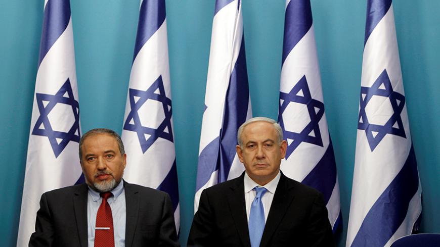 Israel's Prime Minister Benjamin Netanyahu (R) sits next to Foreign Minister Avigdor Lieberman after delivering a statement in Jerusalem November 21, 2012. REUTERS/Baz Ratner/File Photo - RTSEZH2