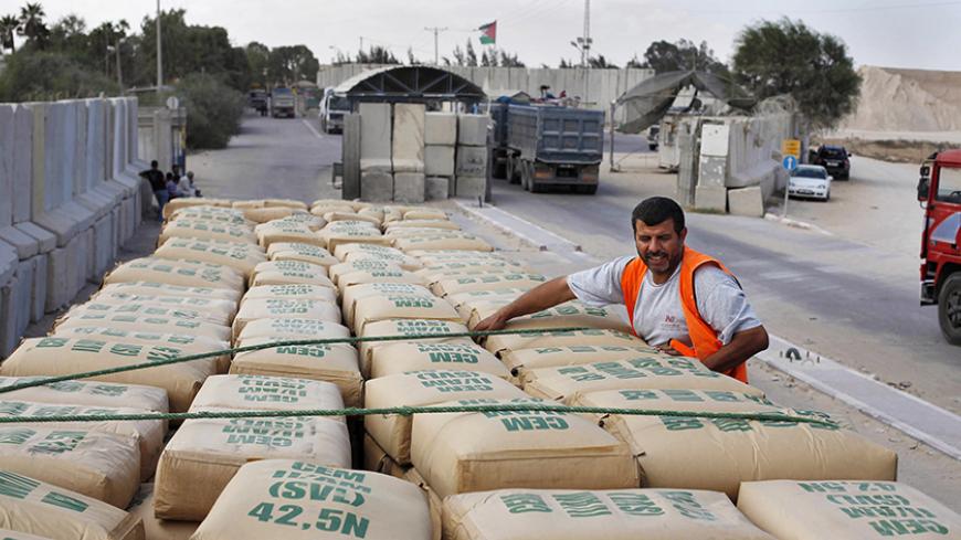 A Palestinian worker checks a truck loaded with cement bags after entering the Gaza Strip through the Kerem Shalom crossing September 22, 2013. Israel began allowing construction material for private projects into the Gaza Strip on Sunday for the first time in six years, in response to a request from Palestinian President Mahmoud Abbas, an Israeli defence official said.  REUTERS/Ibraheem Abu Mustafa (GAZA - Tags: POLITICS BUSINESS CONSTRUCTION REAL ESTATE) - RTX13UHI