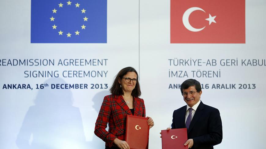 Turkey's Foreign Minister Ahmet Davutoglu and EU Home Affairs Commissioner Cecilia Malmstrom pose during the Turkey-EU Readmission Agreement Signing Ceremony in Ankara December 16, 2013. Turkey and the European Union signed an agreement on Monday allowing EU governments to send back illegal immigrants crossing into Europe from Turkey in a move highlighting a thaw in relations between Ankara and the 28-member bloc.REUTERS/Umit Bektas (TURKEY - Tags: POLITICS SOCIETY IMMIGRATION) - RTX16KRY