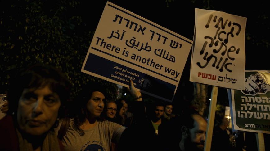 Israeli left wing demonstrators march holding placards protesting the right wing incitement against President Reuven Rivlin and human rights activists in Tel Aviv. December 19, 2015. An ultra-nationalist Israeli group has published a video accusing the heads of four of Israel's leading human rights organisations of being foreign agents funded by Europe and supporting Palestinians "involved in terrorism". The sign (C) reads, "The right will not silence me." REUTERS/Baz Ratner - RTX1ZETU