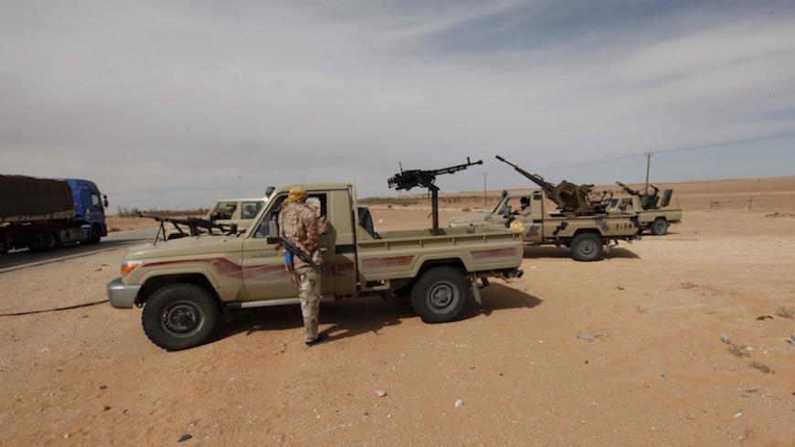 Libyan military vehicles are pictured at a checkpoint in Wadi Bey, west of the Islamic State-held city of Sirte, February 23, 2016. REUTERS/Ismail Zitouny - RTX28G1V