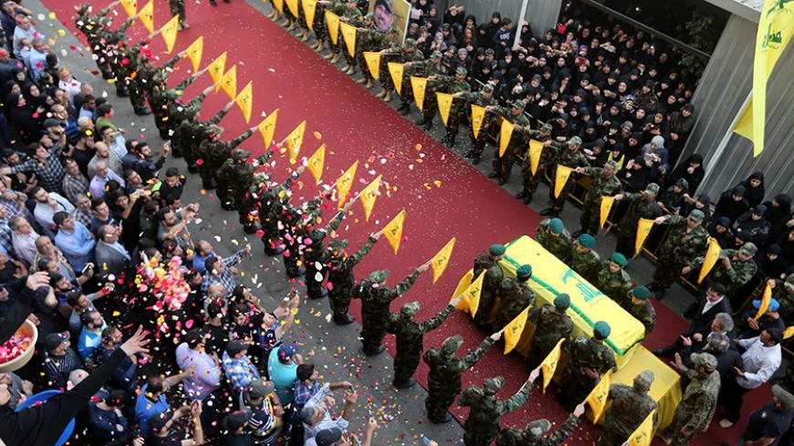 People toss rose petals as Hezbollah members stand near the coffin of top Hezbollah commander Mustafa Badreddine, who was killed in an attack in Syria, during his funeral in Beirut's southern suburbs, Lebanon, May 13, 2016. REUTERS/Hasan Shaaban - RTX2E81S