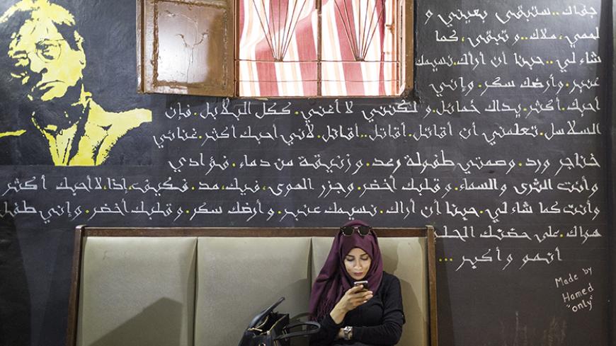 Beirut, Lebanon, 3 June 2016 - A woman on her phone in Jafra café, which is located in the Palestinian refugee camp in Bourj al-Barajneh, Beirut, Lebanon. The café was founded in April 2015 by 34-year old Palestinian musician Ashraf El-Chouli, and is the first mixed meeting place in the camp.