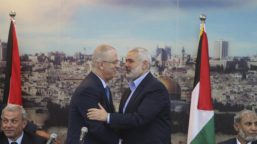 Senior Hamas leader Ismail Haniyeh (R) shakes hands with Palestinian Prime Minister Rami Hamdallah at Haniyeh's house in Gaza City October 9, 2014. Hamdallah arrived in the Hamas-dominated Gaza Strip on Thursday and convened the first meeting of a unity government there since a brief civil war in 2007 between Hamas and forces loyal to the Fatah party.    REUTERS/Ibraheem Abu Mustafa (GAZA - Tags: POLITICS CIVIL UNREST) - RTR49J7M