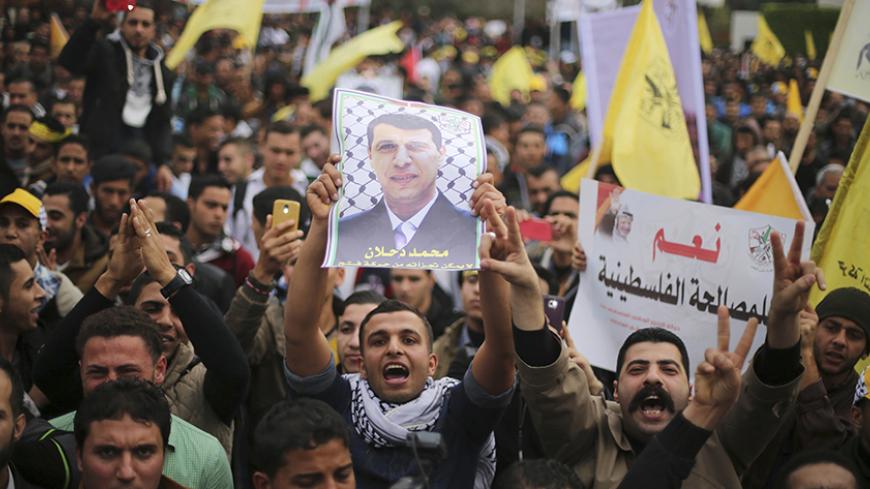 A Palestinian supporter of former head of Fatah in Gaza, Mohammed Dahlan, holds a poster depicting Dahlan during a protest against Palestinian President Mahmoud Abbas in Gaza City December 18, 2014. Dahlan, who lives in exile in the Gulf, is a powerful political foe of Abbas. 
REUTERS/Mohammed Salem (GAZA - Tags: POLITICS CIVIL UNREST) - RTR4IJ8R