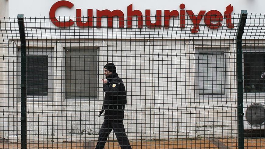A private security employee stands guard at the entrance of daily newspaper Cumhuriyet's offices, in Istanbul January 14, 2015. Turkish police took security measures around the offices of daily newspaper Cumhuriyet after it published a four-page spread of Charlie Hebdo cartoons. REUTERS/Murad Sezer (TURKEY  - Tags: POLITICS CIVIL UNREST CRIME LAW MEDIA) - RTR4LE2U