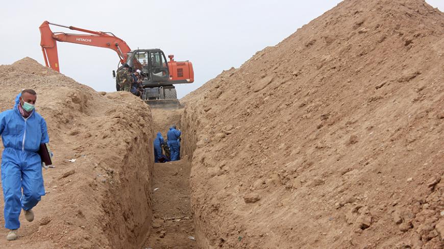 Men excavate remains from a mass grave on the outskirts of Saadia in Diyala province, January 15, 2015. The mass grave contained the remains of more than 25 men who were killed by Islamic State fighters, a hospital official said. Picture taken January 15, 2015.  REUTERS/Stringer (IRAQ - Tags: CIVIL UNREST POLITICS SOCIETY CONFLICT) - RTR4LR1N