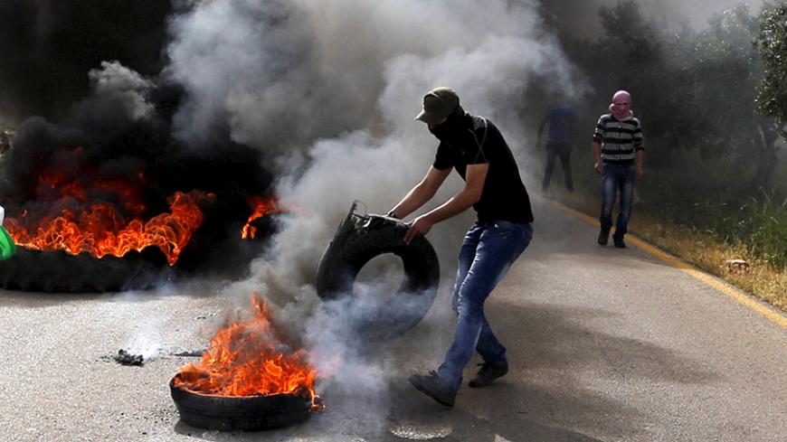 A Palestinian protester sets a tyre ablaze during clashes with Israeli troops in the West Bank village of Duma near Nablus, April 5, 2016. REUTERS/Ammar Awad  - RTSDPPM