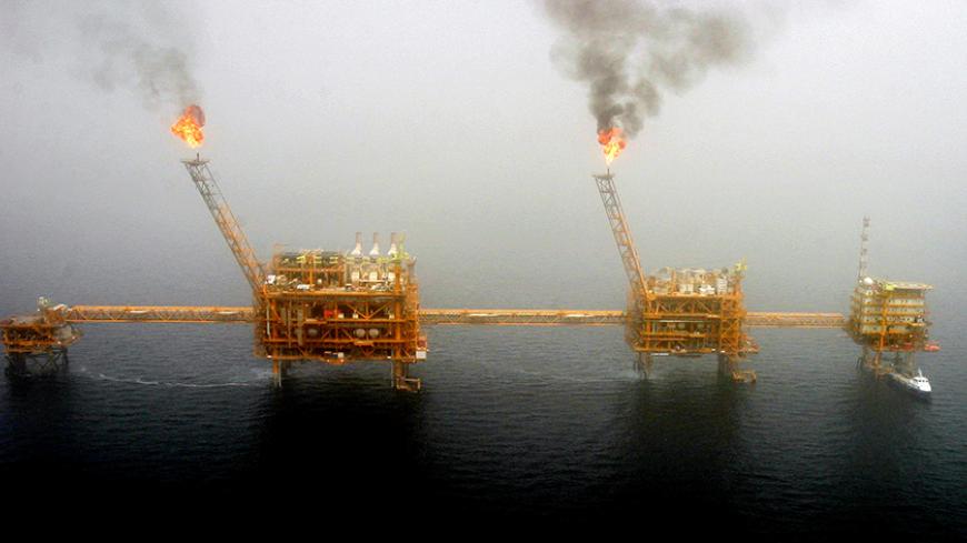 Gas flares from an oil production platform at the Soroush oil fields in the Persian Gulf, south of the capital Tehran, July 25, 2005.  REUTERS/Raheb Homavandi/File Photo - RTSG4X4