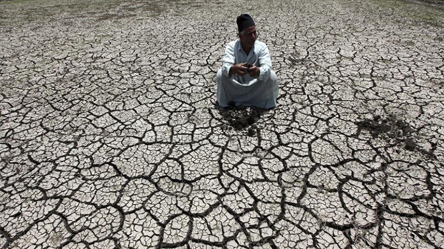 An Egyptian farmer squats down on cracked soil to show the dryness of the land due to drought in a farm formerly irrigated by the river Nile, in Al-Dakahlya, about 120 km (75 miles) from Cairo June 4, 2013. Ethiopia has not thought hard enough about the impact of its ambitious dam project along the Nile, Egypt said on Sunday, underlining how countries down stream are concerned about its impact on water supplies. The Egyptian presidency was citing the findings of a report put together by a panel of experts f