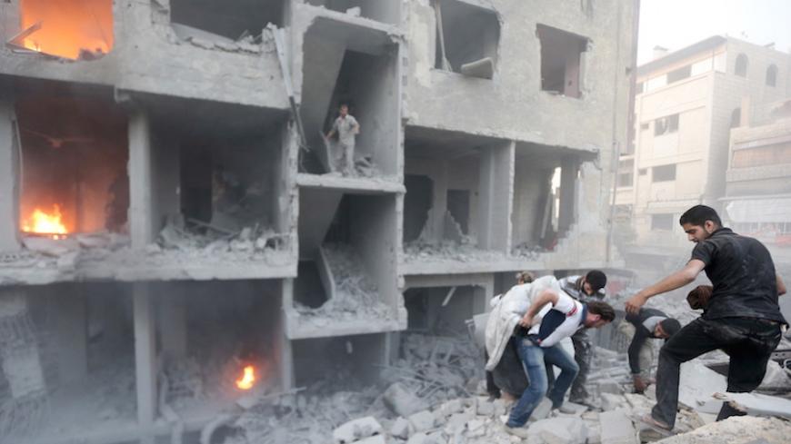 Men search for survivors at a site hit by what activists said was heavy shelling by forces loyal to Syria's President Bashar al-Assad in the Douma neighborhood of Damascus June 16, 2015. REUTERS/Bassam Khabieh - RTX1GSXQ