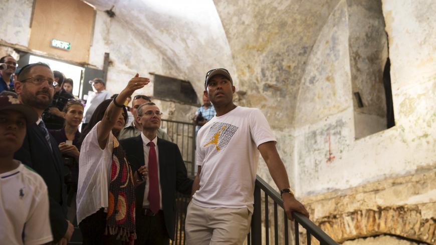 New York Yankees former pitcher Mariano Rivera (C) stands next to Israeli tourism minister Yariv Levin (5th L) as they listen to a tour guide during a visit to the Tower of David in Jerusalem's Old City June 18, 2015. REUTERS/Ronen Zvulun - RTX1H2SQ