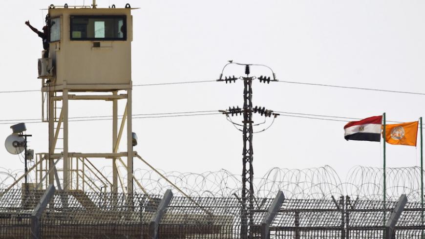 A member of Egypt's security forces gestures as he stands on a watchtower in North Sinai as seen from across the border in southern Israel July 2, 2015. Egypt launched air strikes on Islamist militant targets in the Sinai peninsula on Thursday, killing 23 fighters a day after the deadliest clashes in the region in years, security sources said. The sources said those killed had taken part in Wednesday's fighting in which 100 militants and 17 soldiers, including four officers, were killed, according to the ar