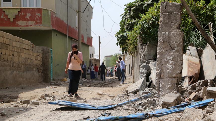 A woman walks along a street in the southeastern Turkish town of Silopi in Sirnak province, near the Turkish-Iraqi border crossing of Habur, Turkey, August 7, 2015. Five people were killed in eastern Turkey on Friday in a series of clashes between security forces and Kurdish militants, part of a surge in violence that has put further strain on a fragile peace process between Ankara and the rebels. Three people were killed and seven wounded during clashes between police and militants of the Kurdistan Workers