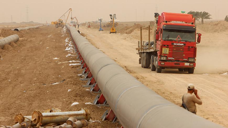 Workers set up a natural gas pipeline during a dust storm at Iraq's border with Iran in Basra, southeast of Baghdad, April 12, 2016.  REUTERS/Essam Al-Sudani - RTX29NH6