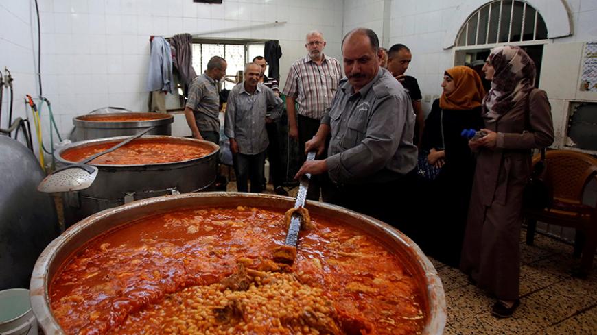 Palestinians prepare food to be distributed for free during the holy fasting month of Ramadan in the West Bank city of Hebron June 13, 2016. REUTERS/Mussa Qawasma  - RTX2FXLB