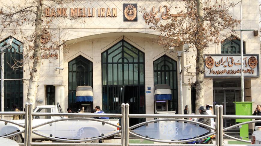 Iranians walk past a branch of Bank Melli in Tehran on January 23, 2012. Top European Union diplomats are meeting in Brussels to tighten existing sanctions on Iran by banning imports of Iranian crude as well as targeting finance, petrochemicals and gold to pressure the country. AFP PHOTO/ATTA KENARE (Photo credit should read ATTA KENARE/AFP/Getty Images)