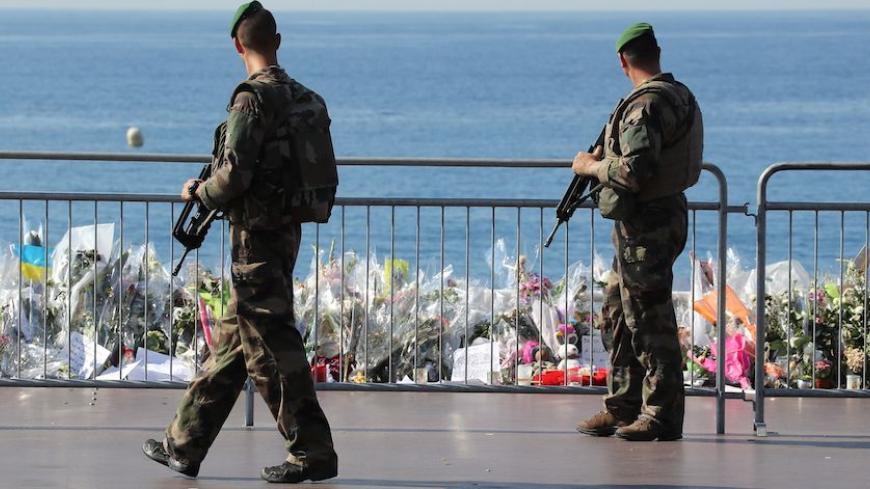 Soldiers pass by the new makeshift memorial in tribute to the victims of the deadly Bastille Day attack at the Promenade des Anglais on July 19, 2016 in Nice, after it was moved from the pavement of the road to the seafront so that the street can be re-opened.
The Islamic State group claimed responsibility for the truck attack that killed 84 people in Nice on France's national holiday, a news service affiliated with the jihadists said on July 16. Tunisian Mohamed Lahouaiej-Bouhlel, 31, smashed a 19-tonne tr