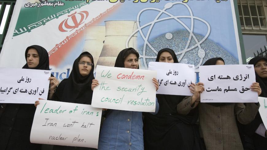 Iranian students hold placards during a rally at Iran's Atomic Energy Organization to mark the country's national day of nuclear technology April 9, 2007. The billboard reads: "As a local achievement, nuclear energy is a source of pride for Iran and the world of Islam".   REUTERS/Raheb Homavandi (IRAN) - RTR1OGOY