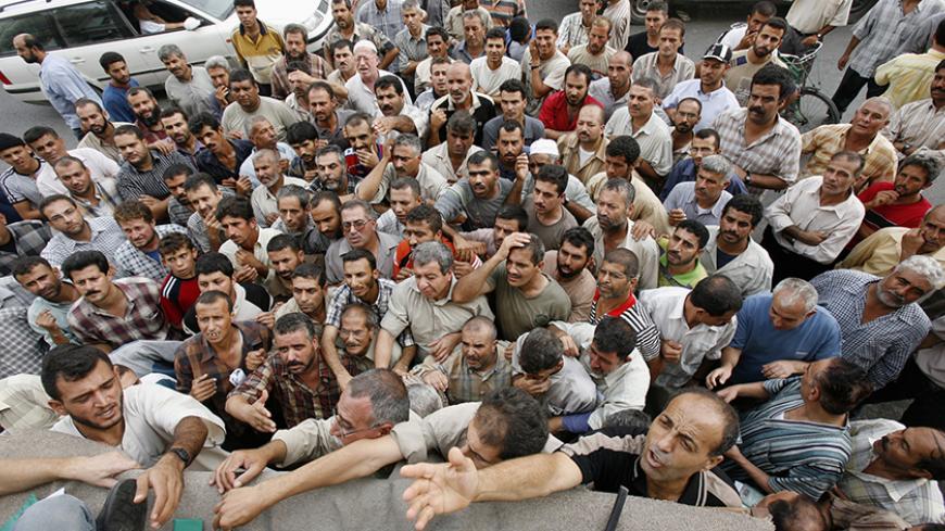 Unemployed Palestinian workers crowd in front of the Palestine Islamic Bank in Gaza to receive a $100 aid from the government appointed by Palestinian President Mahmoud Abbas September 30, 2007.  REUTERS/Mohammed Salem (GAZA) - RTR1UFIM