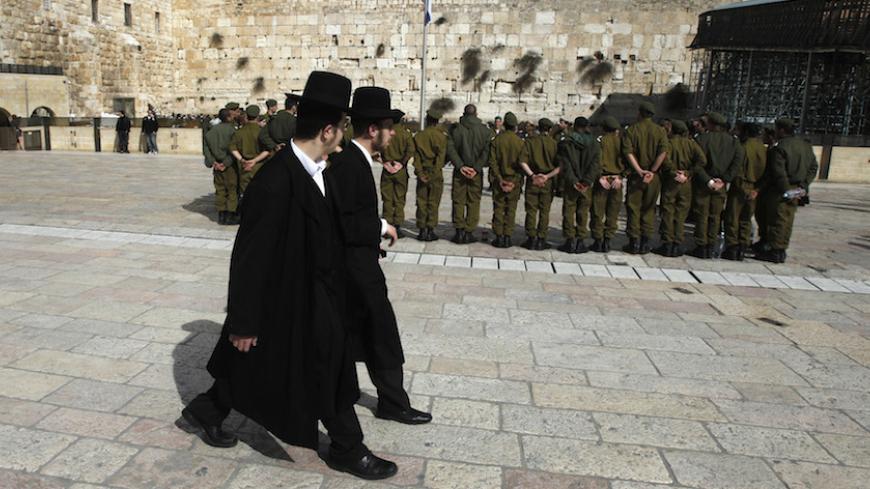 Ultra-Orthodox Jewish men walk behind Israeli soldiers at the Western Wall, Judaism's holiest prayer site, in Jerusalem's Old City February 22, 2012. The Israeli Defence Force (IDF) has always been a 'Jewish' army. Its rations are kosher, its chaplains are rabbis, and it operates - with the exception of wartime - around the festival calendar. It has never drafted soldiers from Israel's 20-percent Arab minority. But its Jewish identity has always been more cultural than religious. IDF personnel data suggests