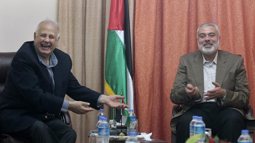 Hamas prime minister Ismail Haniyeh (R) gestures during a meeting with Hanna Nasir (L), chairman of the Palestinian Central Election Commission (CEC), in Gaza City January 30, 2013.  REUTERS/Ahmed Zakot (GAZA - Tags: POLITICS) - RTR3D57Q