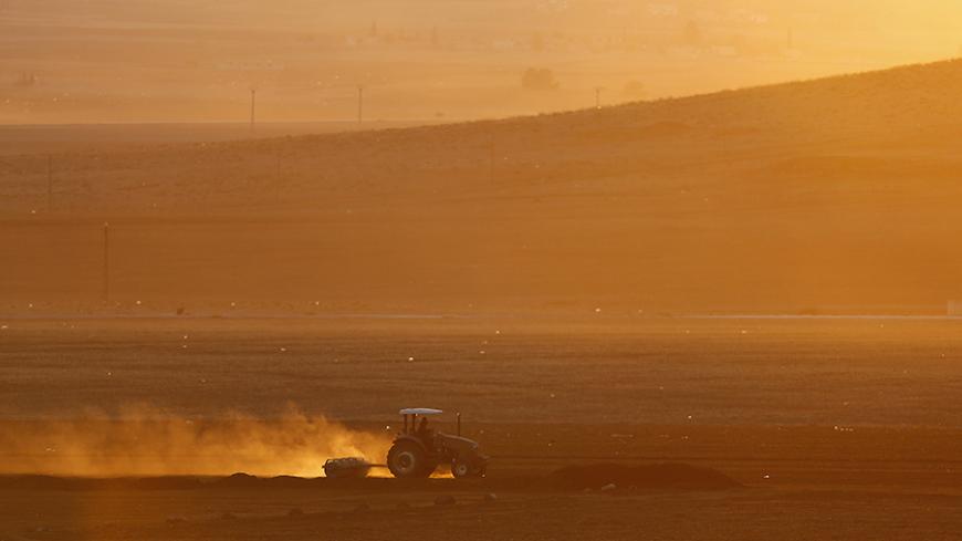 A Turkish farmer works on his field near the Mursitpinar border crossing on the Turkish-Syrian border in the southeastern town of Suruc in Sanliurfa province November 18, 2014. REUTERS/Osman Orsal (TURKEY - Tags: AGRICULTURE SOCIETY) - RTR4ELK1