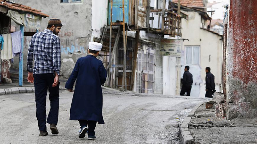 A man and a boy walk a long a street after they attending Friday prayers at Hacibayram district of Ankara November 21, 2014.  Picture taken November 21, 2014. REUTERS/Umit Bektas (TURKEY - Tags: SOCIETY) - RTR4GIZA