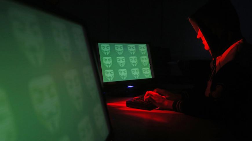 Man poses in front of on a display showing the word 'cyber' in binary code, in this picture illustration taken in Zenica December 27, 2014. A previously undisclosed hacking campaign against military targets in Israel and Europe is probably backed by a country that misused security-testing software to cover its tracks and enhance its capability, researchers said. Picture taken December 27, 2014. REUTERS/Dado Ruvic (BOSNIA AND HERZEGOVINA - Tags: SCIENCE TECHNOLOGY CRIME LAW TPX IMAGES OF THE DAY) - RTR4JEYI