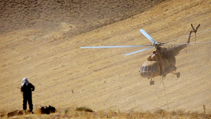 An Iranian sniper stands on a hill as a helicopter flies overhead in military manoeuvres in western Iran, September 18, 2004. The manoeuvre by Iran's elite Revolutionary Guards are taking place near the border with Iraq. REUTERS/Fars News Agency  MN/DBP - RTRB3OE