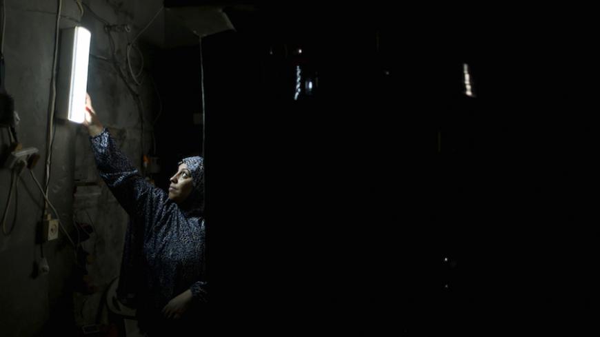 A Palestinian woman hangs a torch inside her house during power cuts at Shatti (beach) refugee camp in Gaza City September 15, 2015. Power has been provided to different areas in the impoverished coastal territory in six-hour shifts as Gaza's lone power plant shut its generators on Saturday due to a fuel shortage, energy officials said. Electricity is also supplied to the Gaza grid through power lines from Israel and Egypt. Gaza's plant provides electricity to two-thirds of its population. REUTERS/Mohammed 