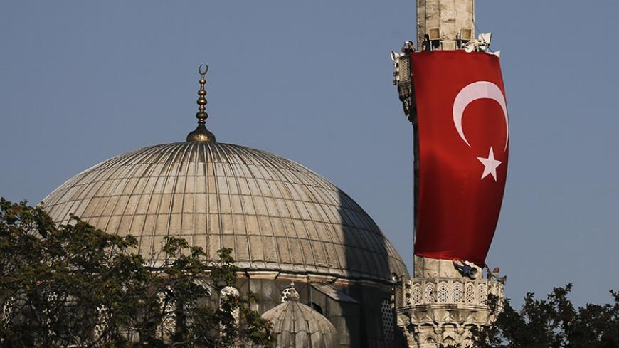 A Turkish flag is seen next to the dome of a mosque in Istanbul, Turkey, July 16, 2016.    REUTERS/Alkis Konstantinidis - RTSIBCJ