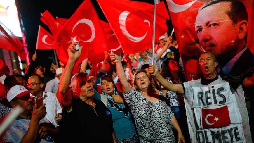 People shout slogans and wave Turkish national flags as they have gathered in solidarity night after night since the July 15 coup attempt in central Ankara, Turkey, July 27, 2016. The banner on the right reads "Chief (Erdogan) I came to die". REUTERS/Umit Bektas - RTSJZ33