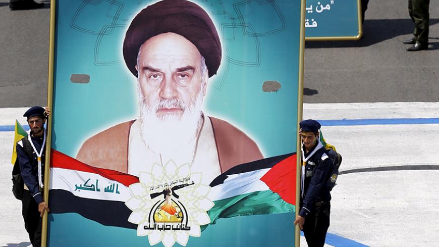Iraqi Shiite Muslim men from Hashid Shaabi (Popular Mobilization) hold portraits of (front to back) Iran's late leader Ayatollah Ruhollah Khomeini, Iraq's late Shi'ite cleric Mohammed Baqir al-Sadr, and Supreme Leader Ayatollah Ali Khamenei during a parade marking the annual al-Quds Day, or Jerusalem Day, on the last Friday of the Muslim holy month of Ramadan in Baghdad, July 10, 2015. REUTERS/Thaier al-Sudani  - RTX1JVWV