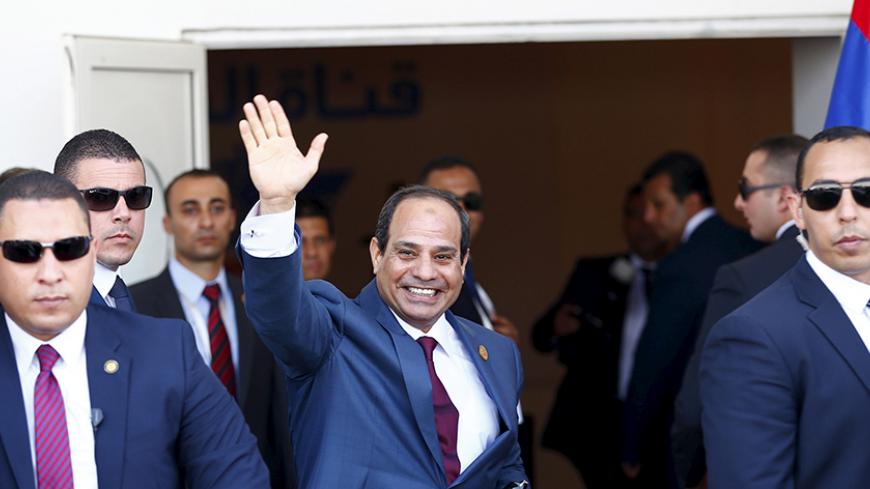 Egyptian President Abdel Fattah al-Sisi (C) waves as he arrives to the opening ceremony of the New Suez Canal, in Egypt August 6, 2015. Al-Sisi publicly signed an order on Thursday to allow ships passage through the New Suez Canal. REUTERS/Amr Abdallah Dalsh - RTX1NBUP