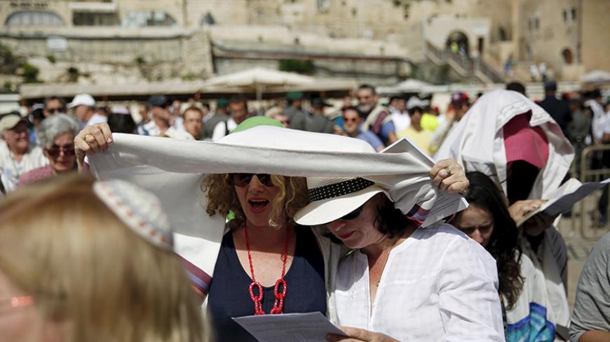 Members of the activist group "Women of the Wall" wear Jewish prayer shawls which the Orthodox Jewish community traditionally reserves for men, during an event for the Jewish holy day of Passover near the Western Wall in Jerusalem's Old City, April 24, 2016.  REUTERS/Ronen Zvulun - RTX2BE6W