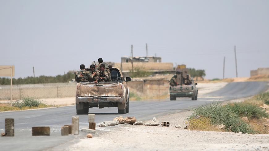 Syria Democratic Forces (SDF) ride vehicles along a road near Manbij, in Aleppo Governorate, Syria, June 25, 2016. REUTERS/Rodi Said - RTX2I6B3