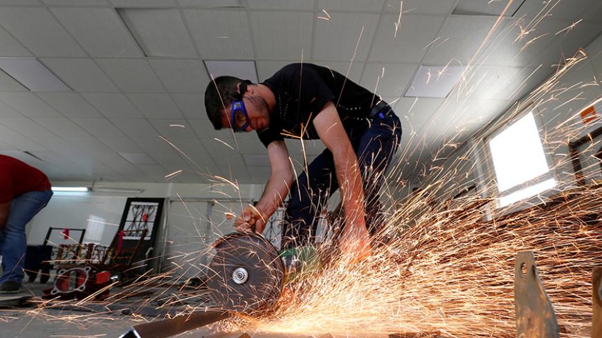 Syrian refugee metal shop trainees work at one of the vocational training centres of The Norwegian Refugee Council (NRC) at Azraq refugee camp near Al Azraq city, Jordan, June 27, 2016. REUTERS/Muhammad Hamed - RTX2IHBY