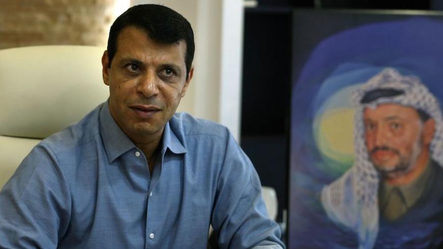 Palestinian senior Fatah official Mohammed Dahlan gestures near a portrait of later Palestinian leader Yasser Arafat during an interview at his office in Abu Dhabi on September 16, 2015. AFP PHOTO / STR / AFP / STR        (Photo credit should read STR/AFP/Getty Images)