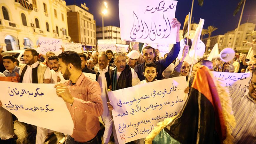 Pro-UN-backed government protesters hold placards and shout slogans during a demonstration in the Libyan capital Tripoli on April 1, 2016.
Hundreds of supporters of the Government of National Accord (GNA) rallied in the capital where the unity cabinet is striving to exert its authority, calling on a rival administration to depart. / AFP / MAHMUD TURKIA        (Photo credit should read MAHMUD TURKIA/AFP/Getty Images)